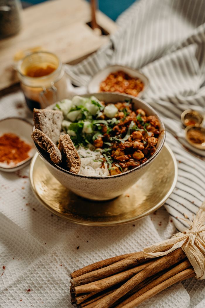 our-story A delicious, healthy vegan bowl featuring chickpeas, rice, cucumbers, and spices. Perfect for a nutritious meal.